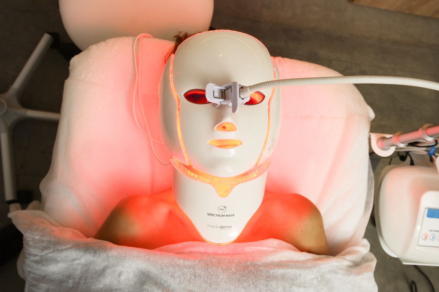 paciente con máscara de fototerapia led con luz roja